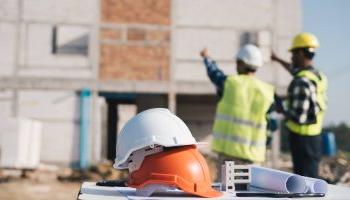 Engineer And Architect Working With Blueprints Discuss At The Outdoors Construction Site